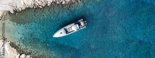 Aerial drone ultra wide photo of small inflatable rib speedboat anchored in beautiful bay of small fishing coastal village of Lefkada, Ionian, Greece