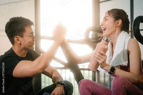 Canvastavla Young slim fitness Asian woman sitting and shake hands with personal trainer conversation for a break in the gym