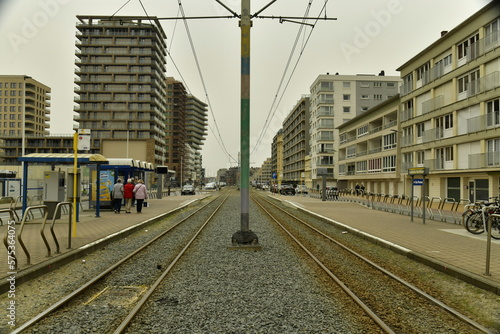 Ligne du Tram de la Côte avec ses caténaires reliant toutes les cités balnéaires belges sous un ciel sombre à Ostende 