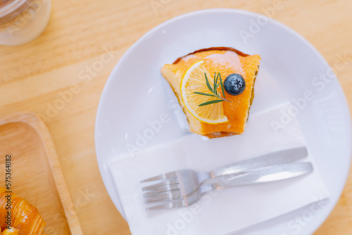 Top view piece of orange cake and sliced orange topping. Cake with orange mousse with copy space