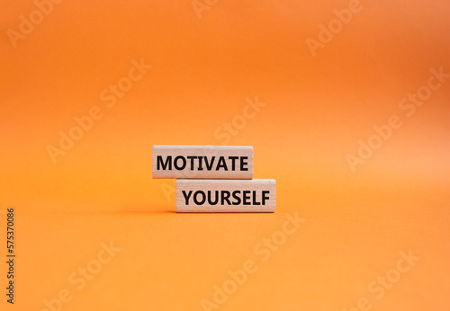 Motivation symbol. Concept words Motivate yourself on wooden blocks. Beautiful orange background. Business and Motivate yourself concept. Copy space.