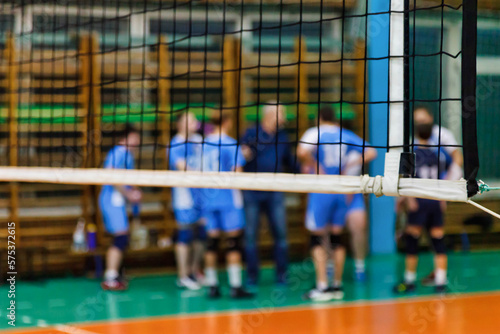 Image background for team volleyball games: coach analyzing game of volleyball team during timeout in school sport gym. Concept of getting sport, healthy lifestyle and team success. Copy ad text space