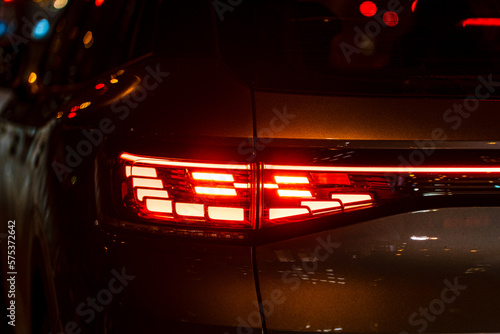 Red illuminated LED taillight on the back of a car at night
