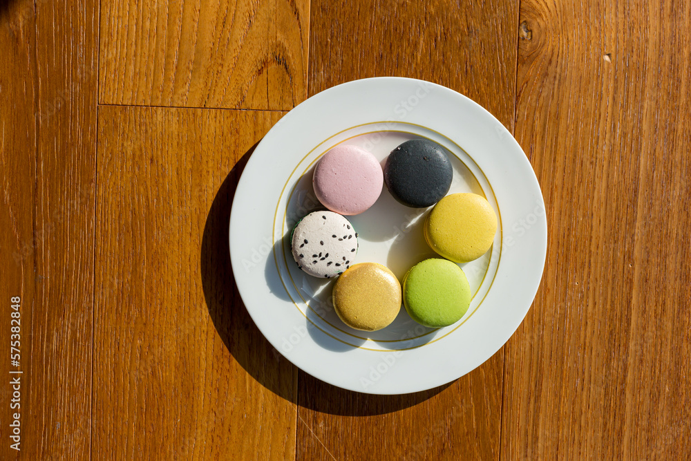 Brown, beige, green and cream colored French macarons on plate Brown, beige, green and cream colored French macarons on plate