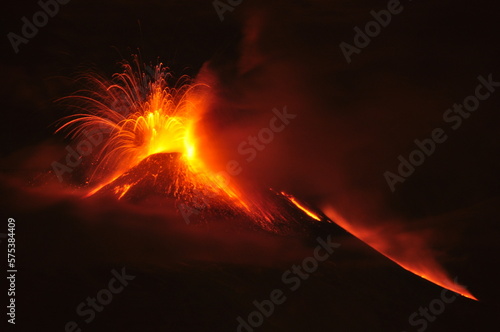 Night view of volcanic eruption showing lava fountains and streams flowing down the Etna sides in Sicily, Italy