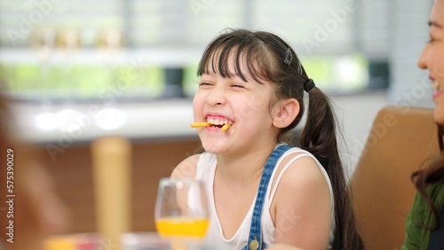 Children laugh at the dining table and have fun during lunch at home. Family time