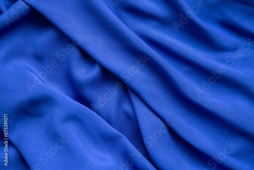 Background from blue fabric in folds. The texture of the fabric.