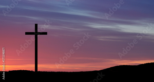 Christian cross on hill outdoors at sunrise. Resurrection of Jesus. Concept photo.