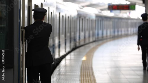 People are Walking on Platform in Metro Train Station Platform in Tokyo. Underground Metro Train During Rush Hour. Conductor is Checking Status photo