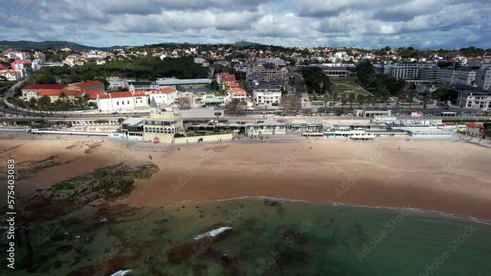 Aerial drone sideways panning Tamariz Beach and promenade in Estoril, Greater Lisbon, Portugal with Casino Estoril in background Aerial drone sideways panning Tamariz Beach and promenade in Estoril, Greater Lisbon, Portugal with Casino Estoril in background