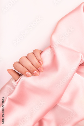 female hands with Japanese manicure on the background of silk