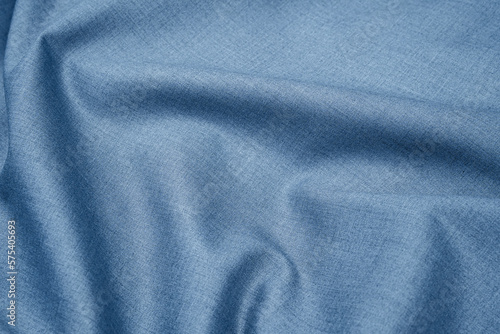 Close-up of texture of plain silver blue fabric with folds. Abstract background of monochrome textile material for design and templates. Copy space.