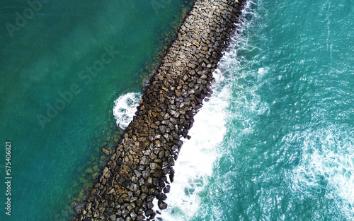 Aerial view of the sea stone breakwater. Beautiful ocean wallpaper for tourism and advertising. Asian landscape, drone photo