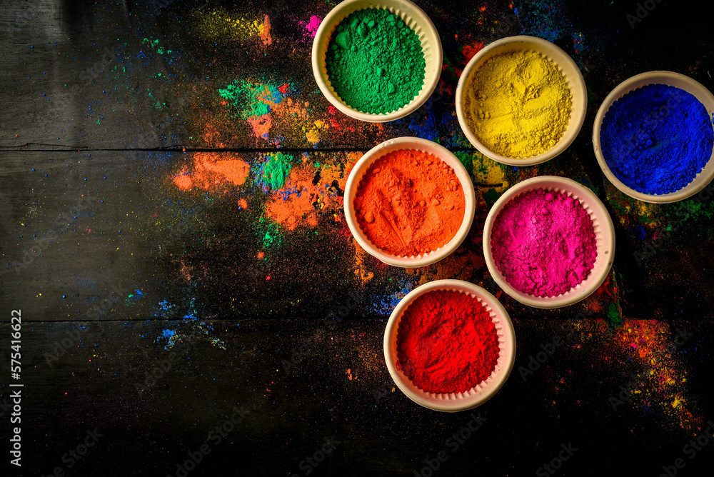 top view of colorful traditional holi powder in bowls isolated on dark background.Space for text . happy holi.Concept Indian color festival called Holi top view of colorful traditional holi powder in bowls isolated on dark background.Space for text . happy holi.Concept Indian color festival called Holi