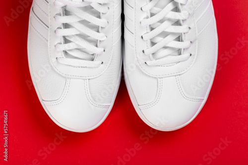 Sport shoes. Pair of White sneaker on red background.