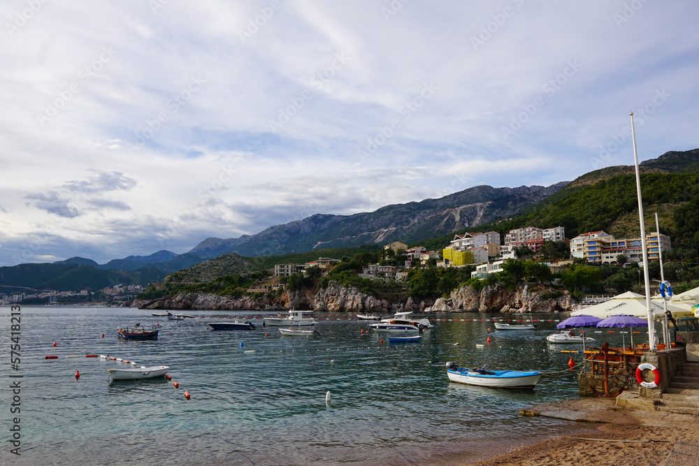 A beach with boats and mountains in the background
