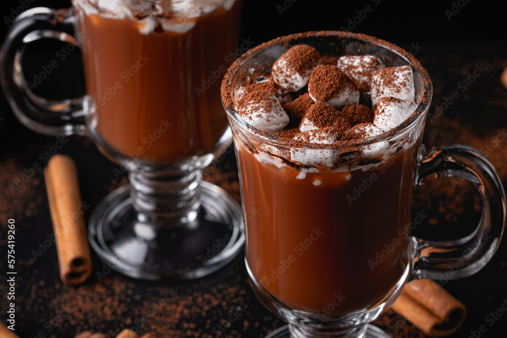 Two cups of hot chocolate, cocoa or warm drink with marshmallows on dark background Two cups of hot chocolate, cocoa or warm drink with marshmallows on dark background
