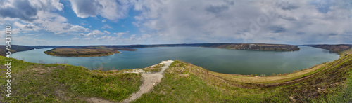 banks of a large river. Bakota, Dniester river, Ukraine. Smooth calm water panoramic landscape. High banks, green hills. Summer day in Eastern Europe.