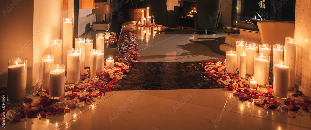 Room decorated with burning candle lights in darkness. Romantic background