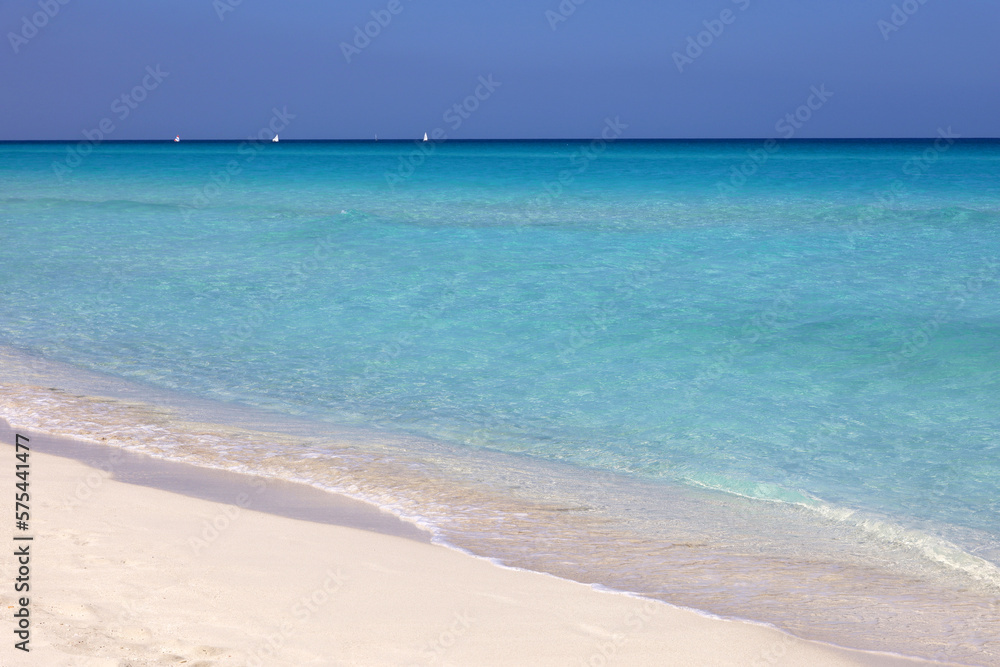 Tropical beach with white sand on a ocean, view to blue waves and sky. Background for holidays on a paradise nature