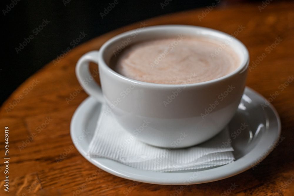 white cup with hot latte coffee on a wooden table. horizontal white cup with hot latte coffee on a wooden table. horizontal
