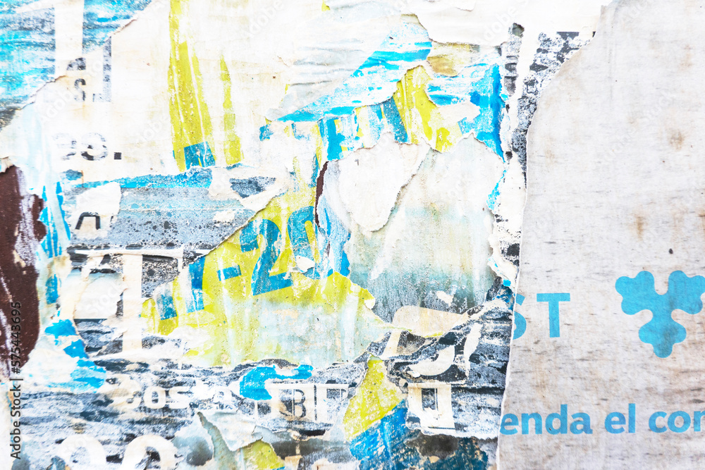 Fototapeta premium Old grunge torn collage urban street posters creased crumpled paper placard texture background. Ripped faded paper backdrop surface placard