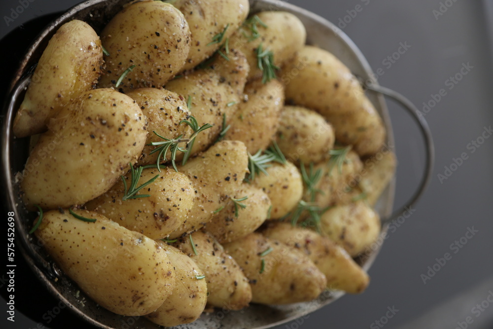 halved potatoes garnished with thyme, salt and pepper for oven roasting halved potatoes garnished with thyme, salt and pepper for oven roasting