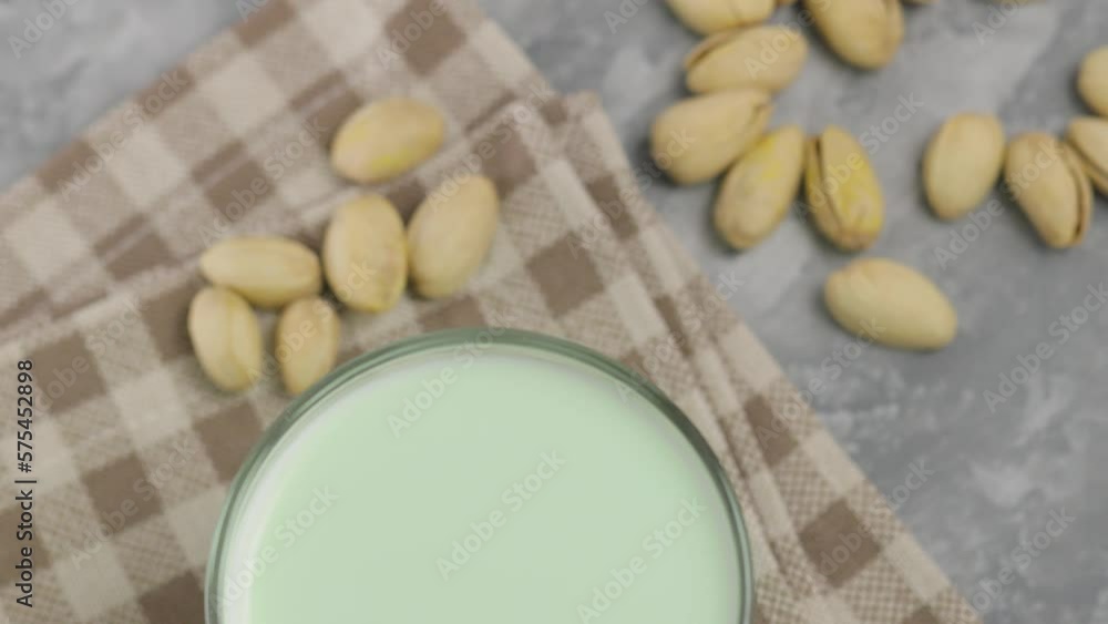 Pistachio milk in a glass on a gray concrete background. Organic lactose free pistachio milk and pistachios. Top view camera Pistachio milk in a glass on a gray concrete background. Organic lactose free pistachio milk and pistachios. Top view camera