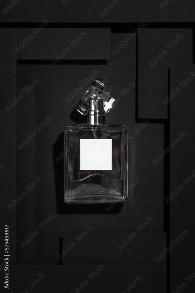Mockup of glass perfume bottle on a dark multi-layered black background. Background for perfume branding, identity and packaging inspiration. Top view. Horizontal