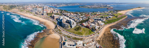 Panoramic aerial drone view of the harbour city of Newcastle, NSW, Australia as a cargo ship enters Newcastle Harbour on a sunny day  photo