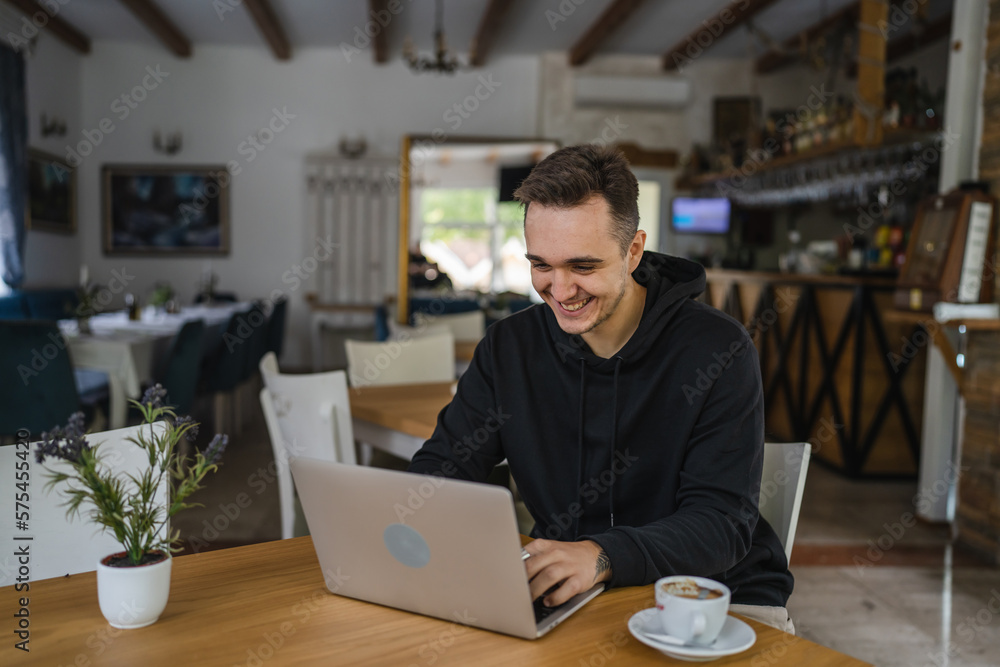 one man work on the computer laptop while sit at cafe or restaurant one man work on the computer laptop while sit at cafe or restaurant
