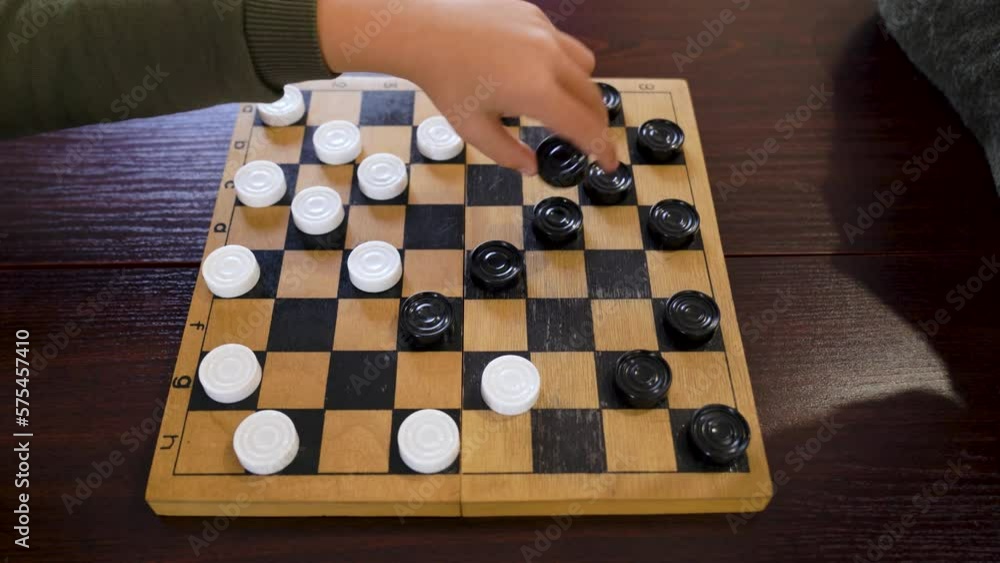 Grandmother and little grandson play checkers sit at table. Grandmother and little grandson play checkers sit at table.