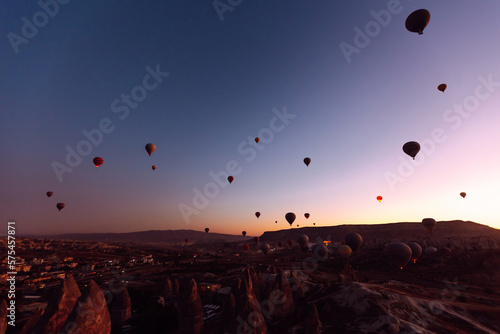 Flying hot air balloons rise in sunrise Cappadocia. Goreme National Park Turkey.