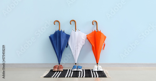 Stylish umbrellas and children's shoes in hall