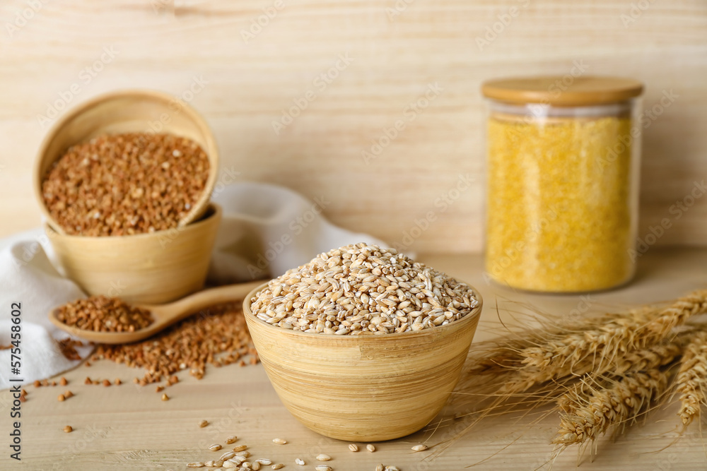 Bowl with pearl barley and spikelets on wooden background Bowl with pearl barley and spikelets on wooden background