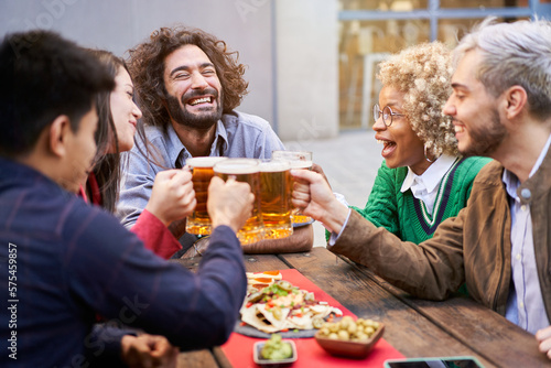 Happy cheerful people toasting beers. Smiling friends holidays. High quality photo