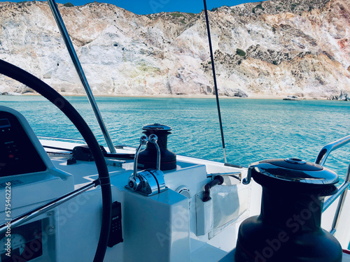 Spectacular geological view of a turquoise Milos island bay as seen from the bridge of a sailing catamaran