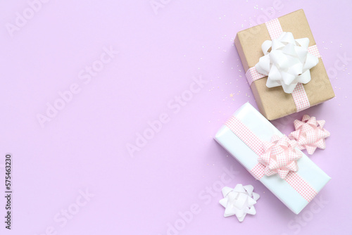 Gift boxes with bows on lilac background © Pixel-Shot