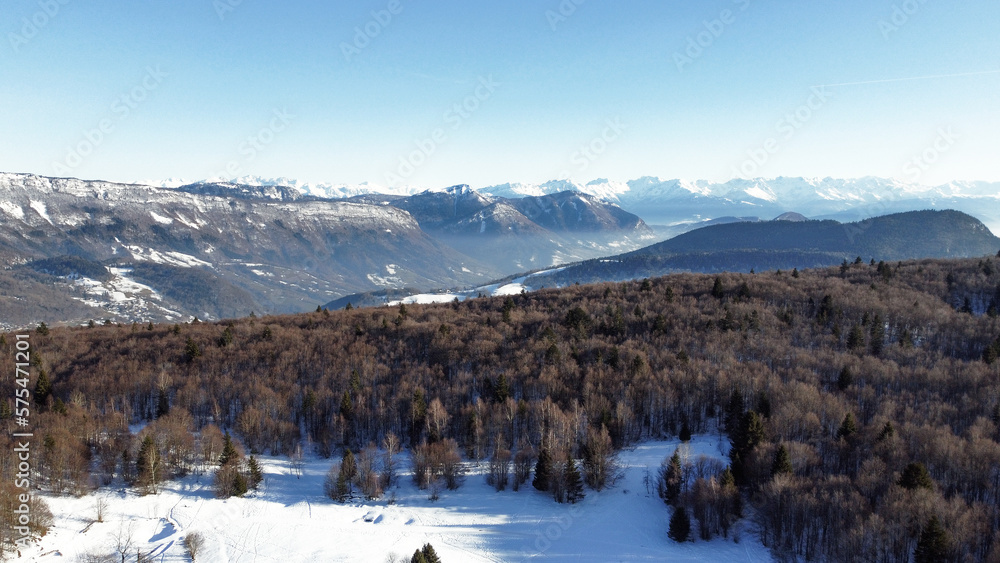 Panoramic view of snowy mountains in winter. Foggy mountains. Woods in front of the mountains.