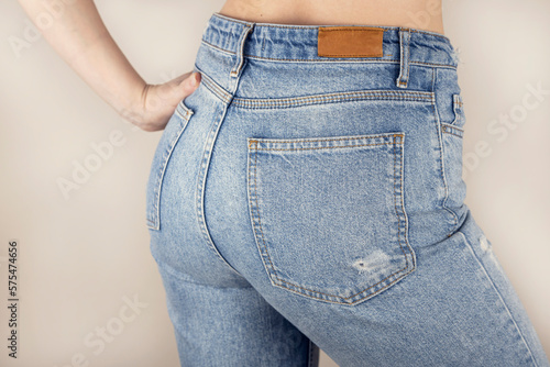 Woman in blue jeans rear view. Female buttocks in jeans on a white background.