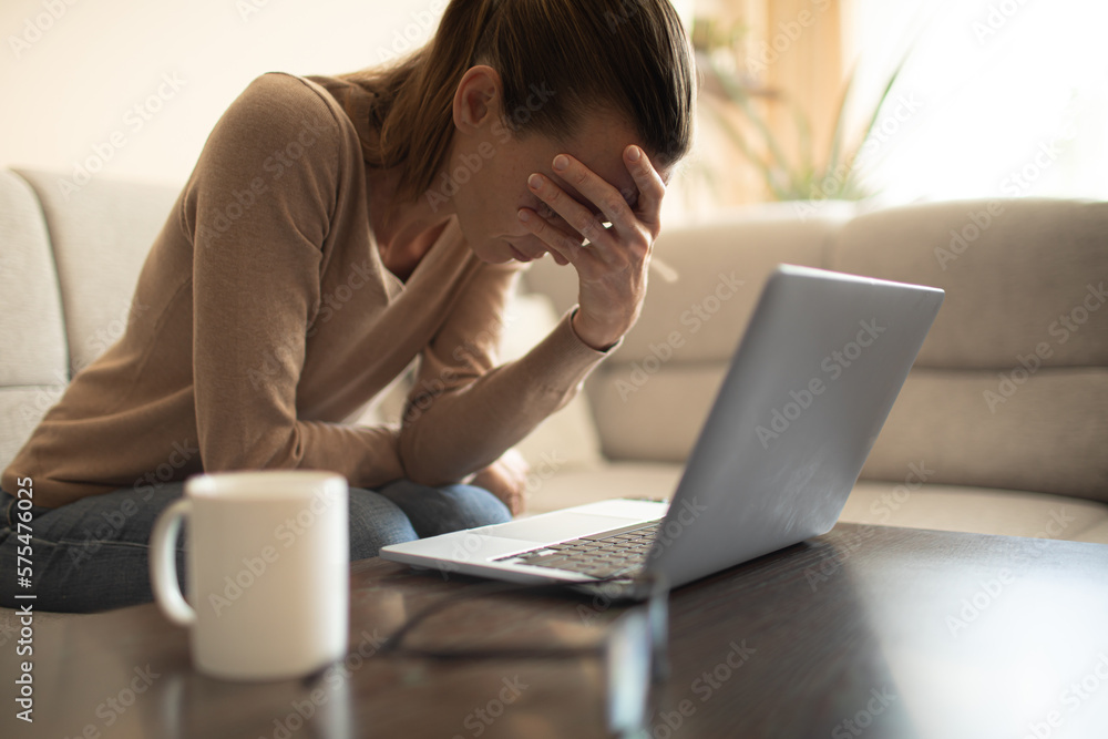 Woman with hand over face next to computer. People work, life problems and difficulties Woman with hand over face next to computer. People work, life problems and difficulties
