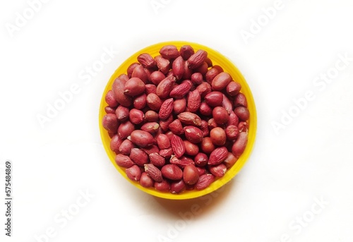Closeup of a small pile of red-skinned peanuts on a white background