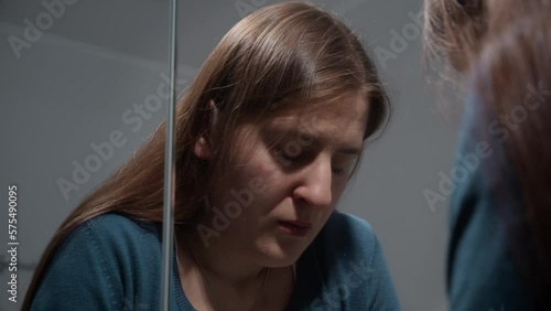 Reflection in mirror of upset woman suffering from problems in life. Concept of depression, stress, mental illness and problems, loneliness and frustration