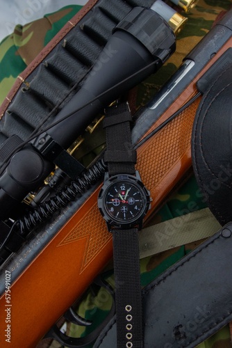 Close up black analog-digital hybrid wristwatch. Military style men watch with military objects. photo