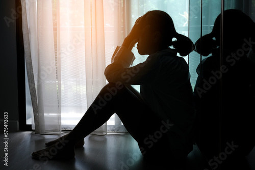 woman sitting in the corner of the room have emotional and mental problems He has depression and stress from society and work. medical concept. photo