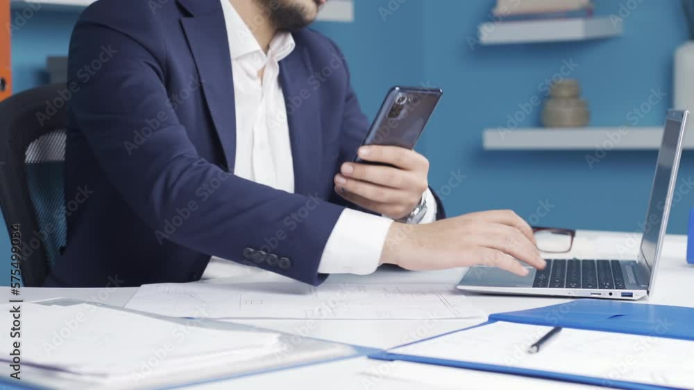 Close-up of businessman using phone in office, giving checkmark to camera, saying ok. Close-up of businessman using phone in office, giving checkmark to camera, saying ok.