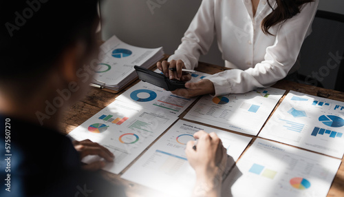 Two business people talk project strategy at office meeting room. Businessman discuss project planning with colleague at modern workplace while having conversation and advice on financial data report.