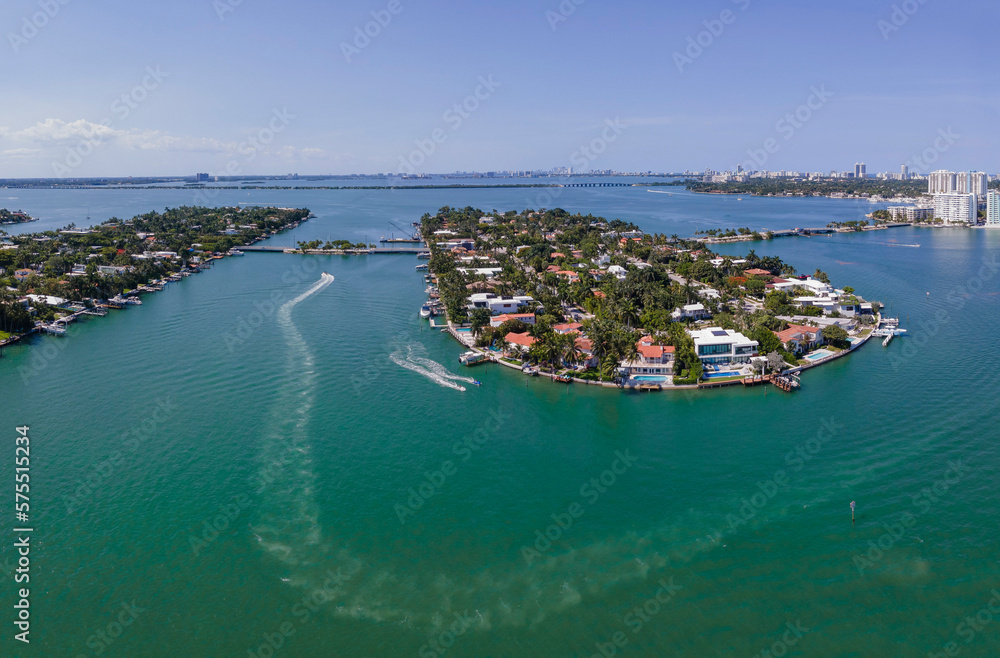 Miami Florida landscape with aerial view of the man made Intracoastal Waterway. Boat and houses built in the middle of the water can be seen under the blue sky.