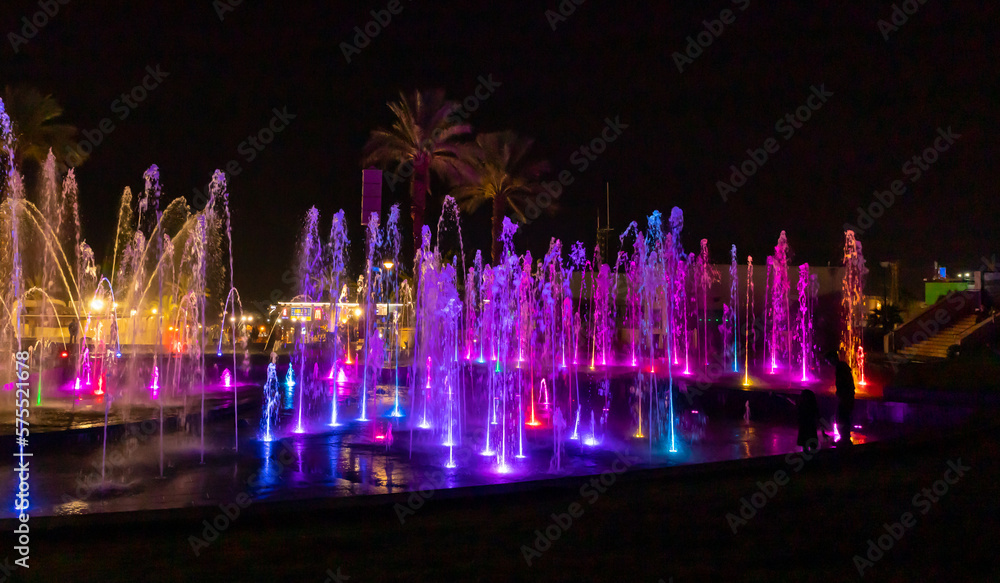 Enchanting grandiose musical performance - water and light show of a musical fountain on the embankment, in the center of the city of Eilat in southern Israel - obrazy, fototapety, plakaty 