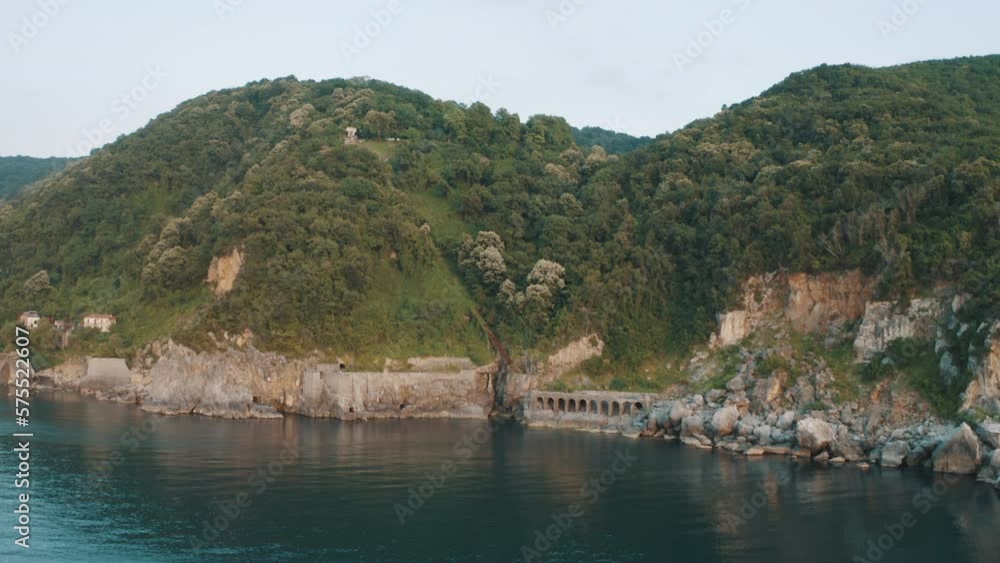 Drone view of the lighthouse in the trees, the white lighthouse building built on the edge of the cliff Drone view of the lighthouse in the trees, the white lighthouse building built on the edge of the cliff